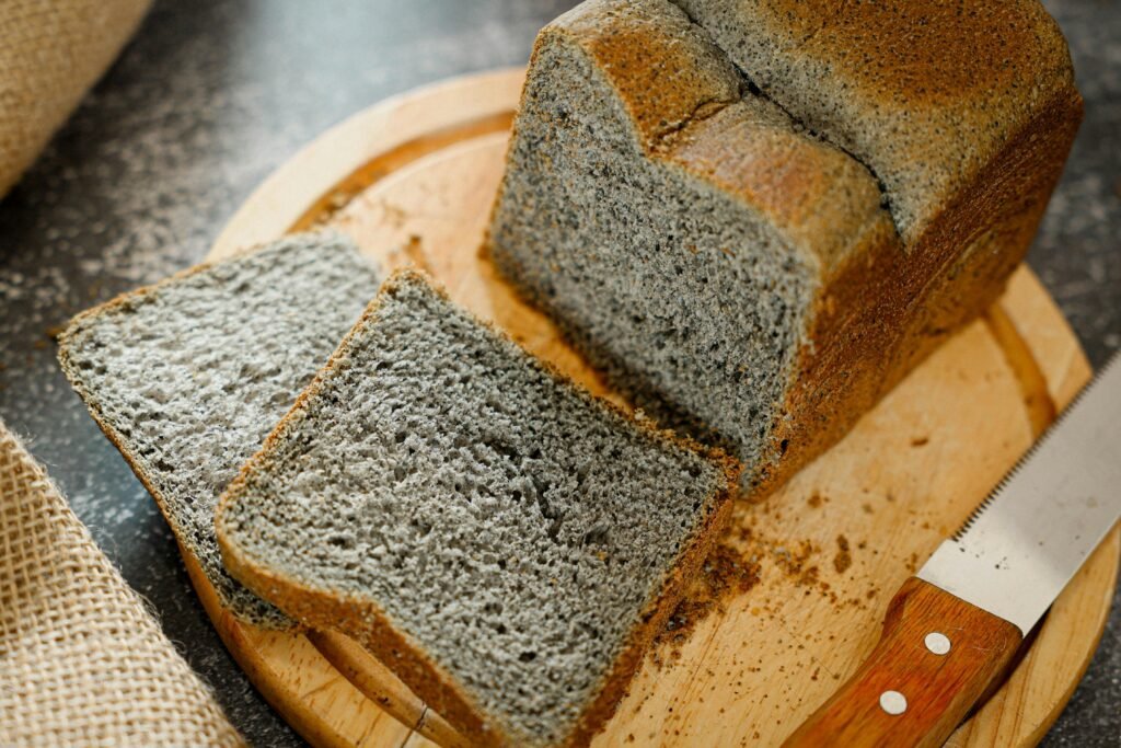 Disfrutar del sin gluten también fuera de casa Delicious freshly baked black sesame bread loaf and slices on a wooden cutting board. Perfect for breakfast or snack.