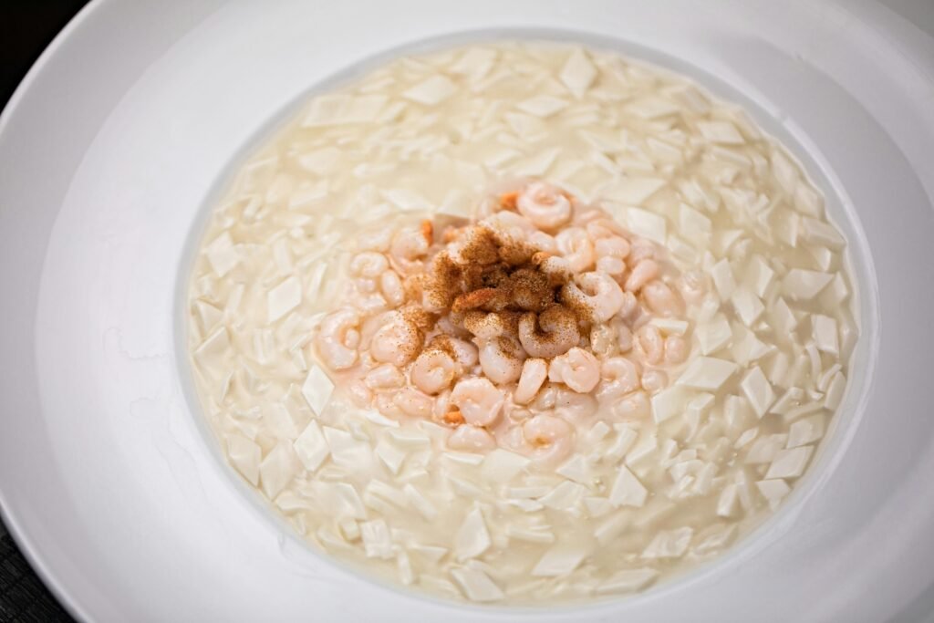 Disfrutar del sin gluten también fuera de casa Delicious creamy tofu soup garnished with seasoned shrimp, offering a gourmet meal experience.